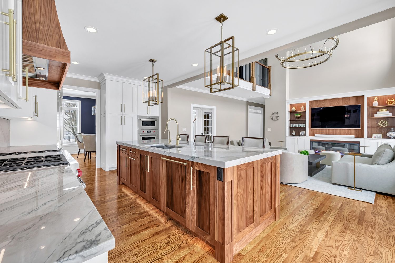 Warm kitchen with a walnut island and open living space beyond