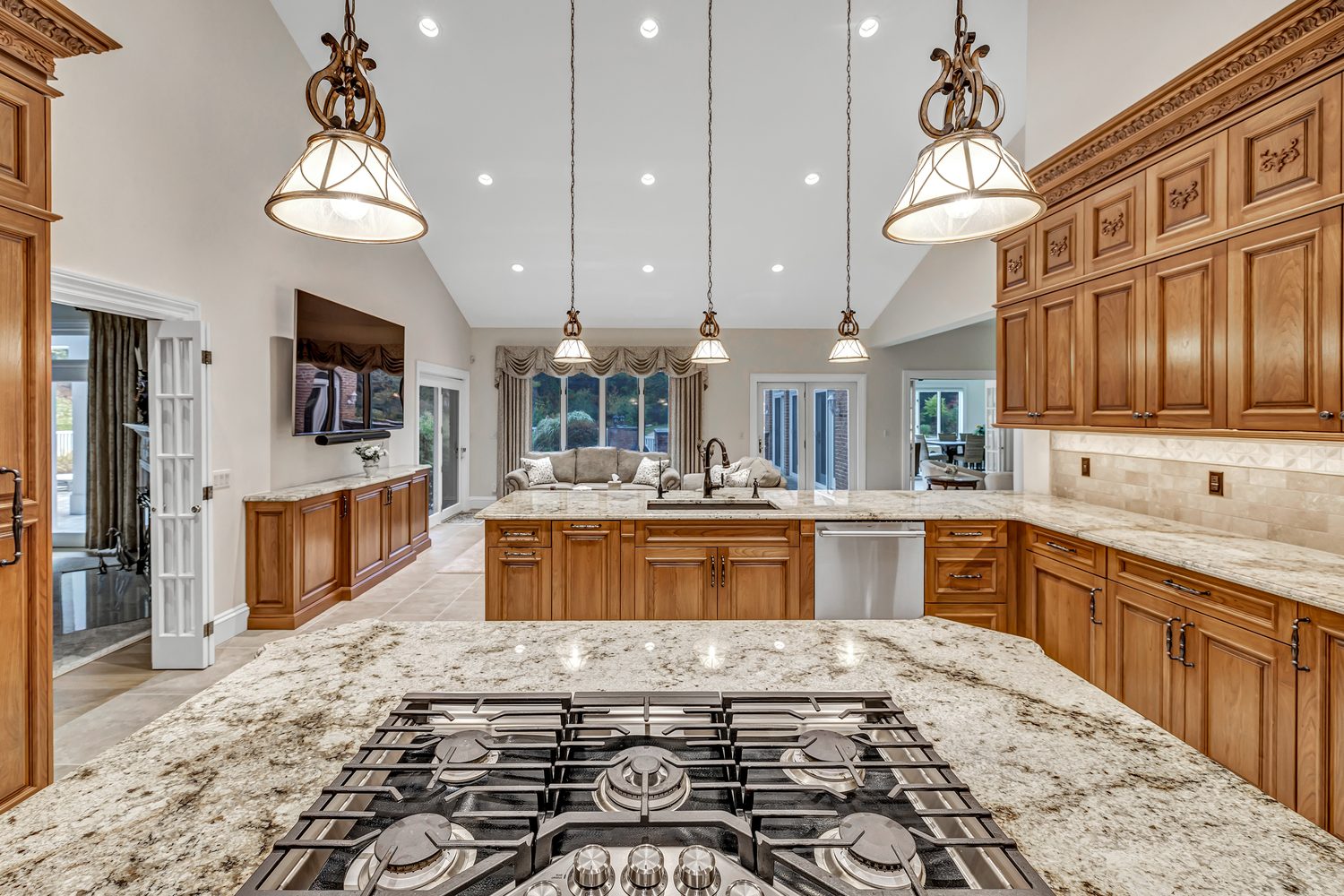 Grand traditional kitchen with warm wood cabinetry, ornate detailing, and a large center island