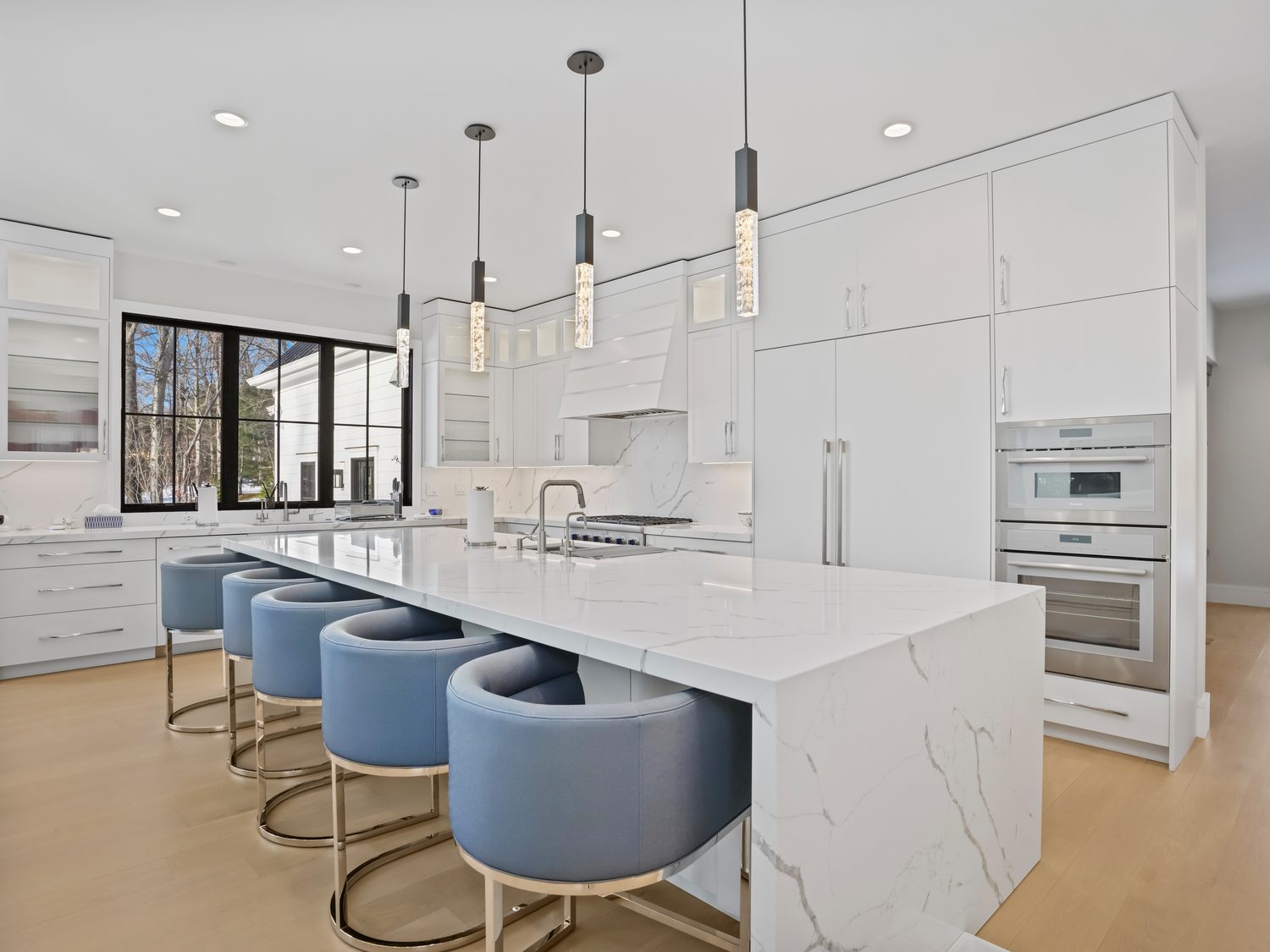 Contemporary slab-door kitchen with integrated appliances and a waterfall island