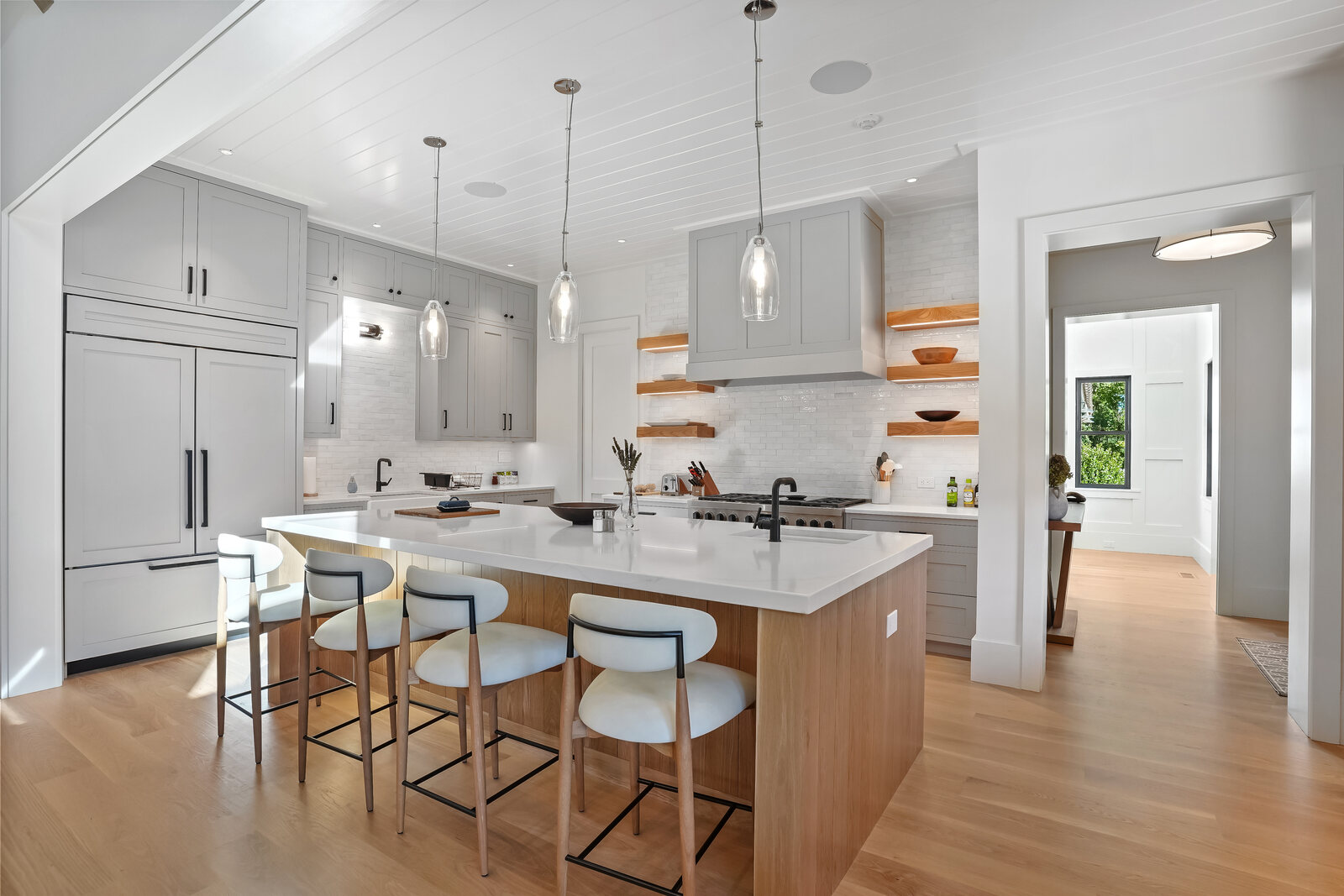 Overall Coastal Retreat kitchen with a white oak island and floating shelves