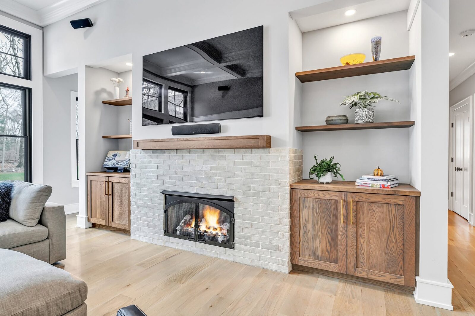 White oak built-ins and floating shelves wrapping a fireplace