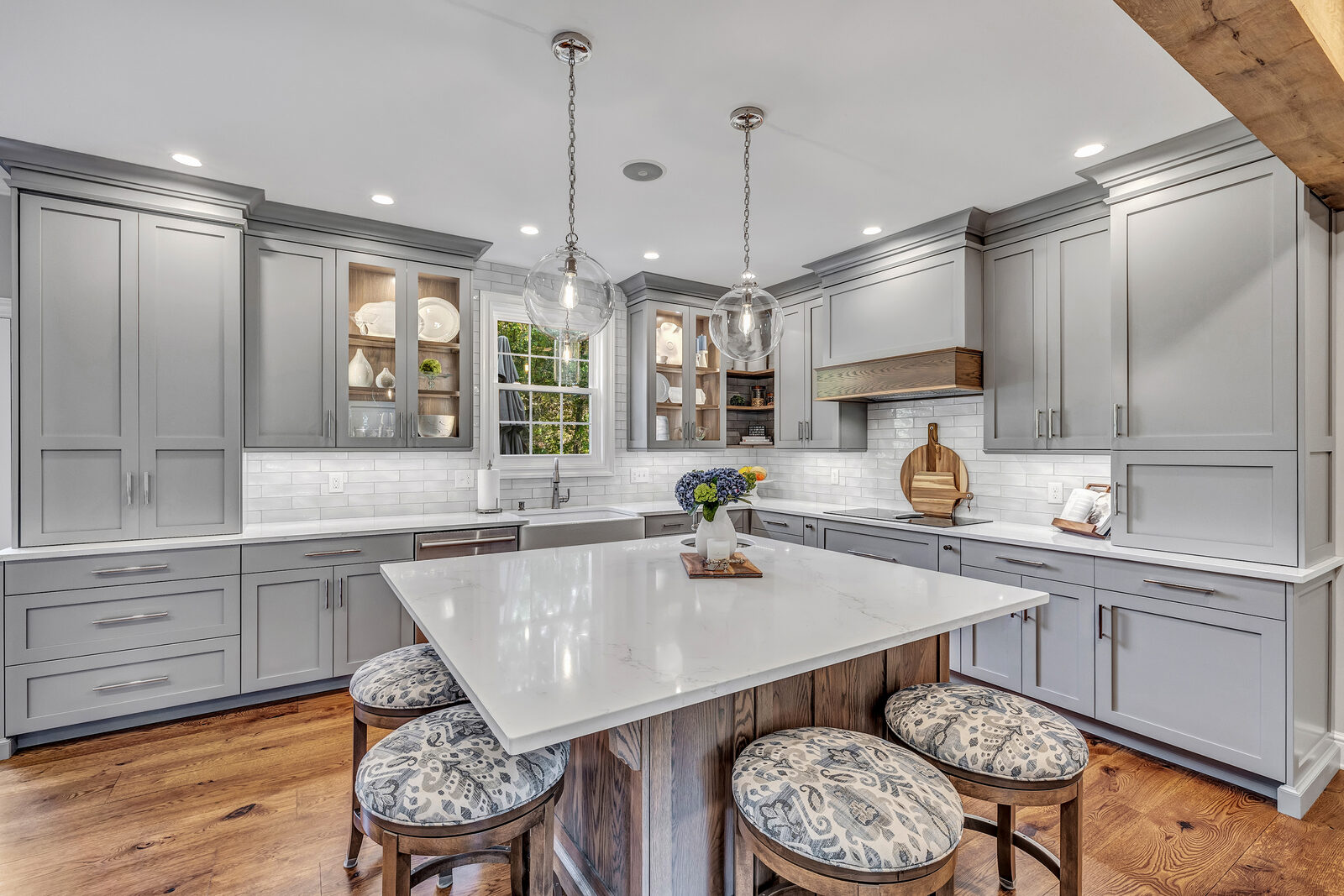 White kitchen with vaulted shiplap ceiling and marble island